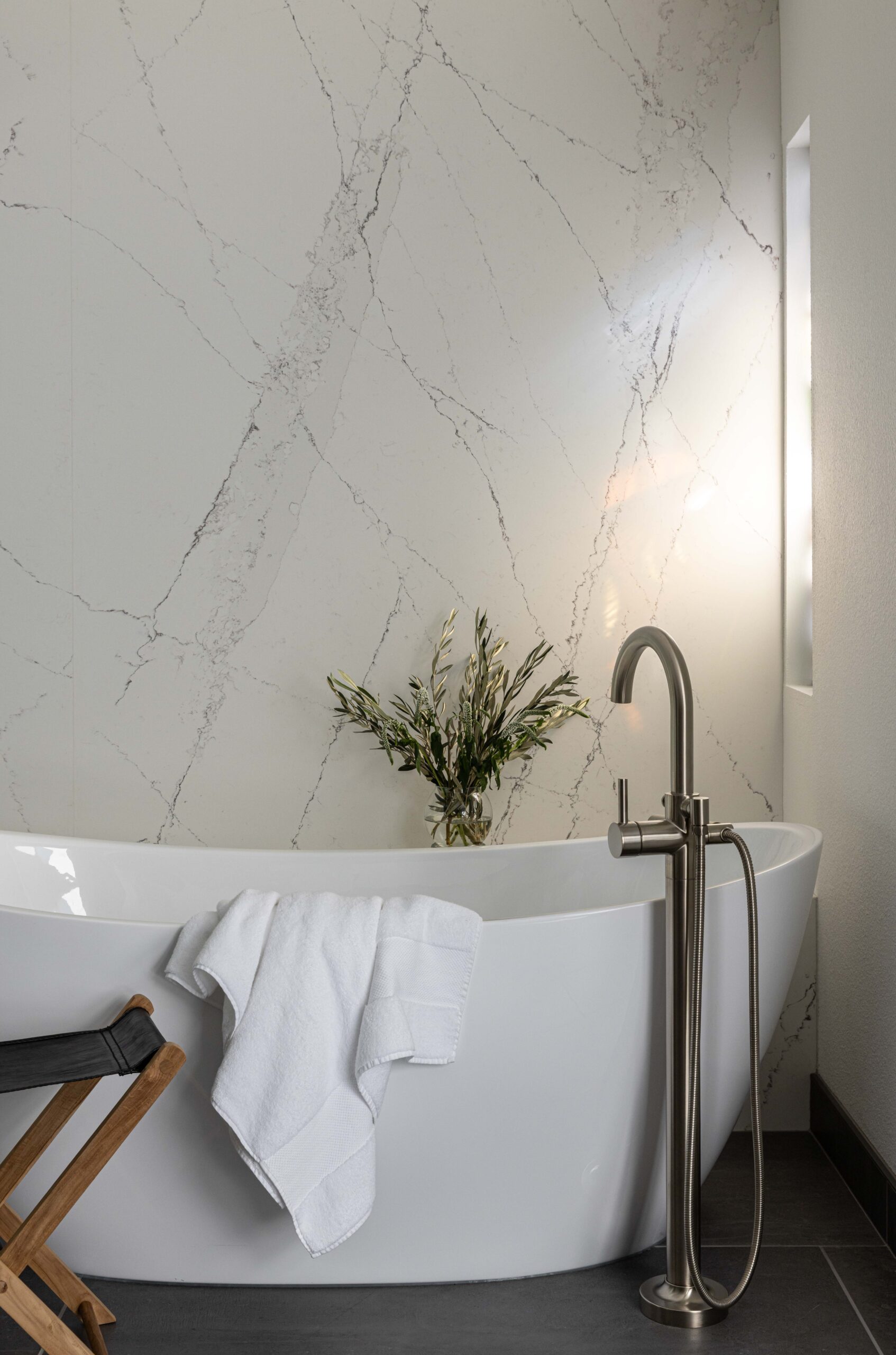 Sacramento Bathroom Designer Freestanding tub with marble wall and black tile floor